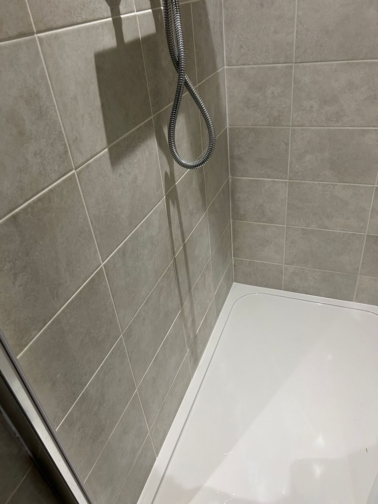 Close-up of neat grey wall tiling and shower tray by Yorkshire Green Heating Doncaster